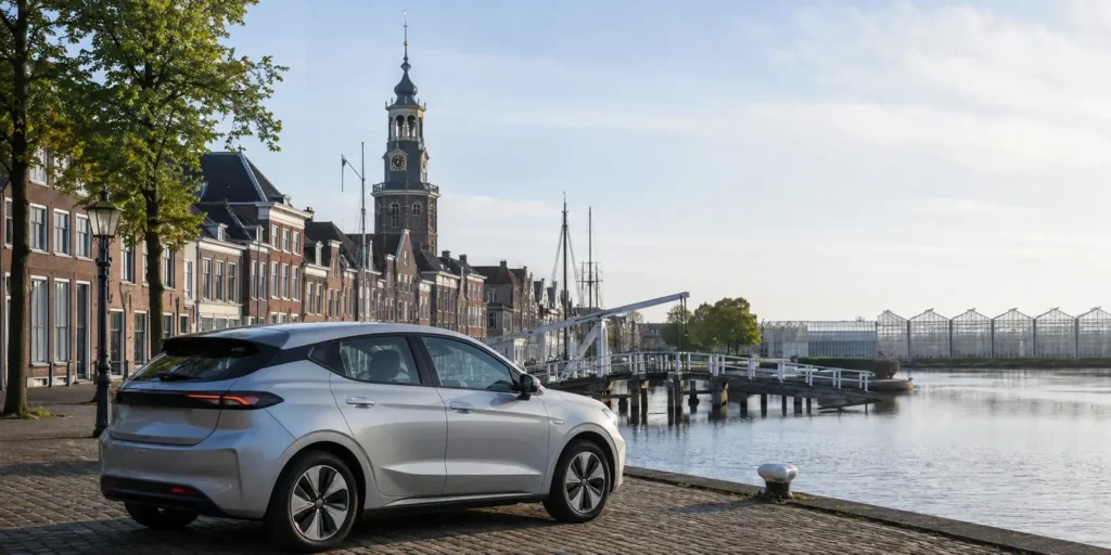 Elektrische auto aan de haven van Maassluis met het Westland op de achtergrond